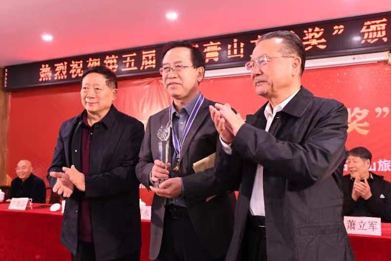 艾克拜尔米吉提和张建新为首奖获得者李春雷颁奖