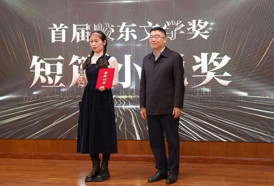 山东省作协党组书记、副主席赵艺丁（右一）  为短篇小说奖获得者王铭婵颁奖