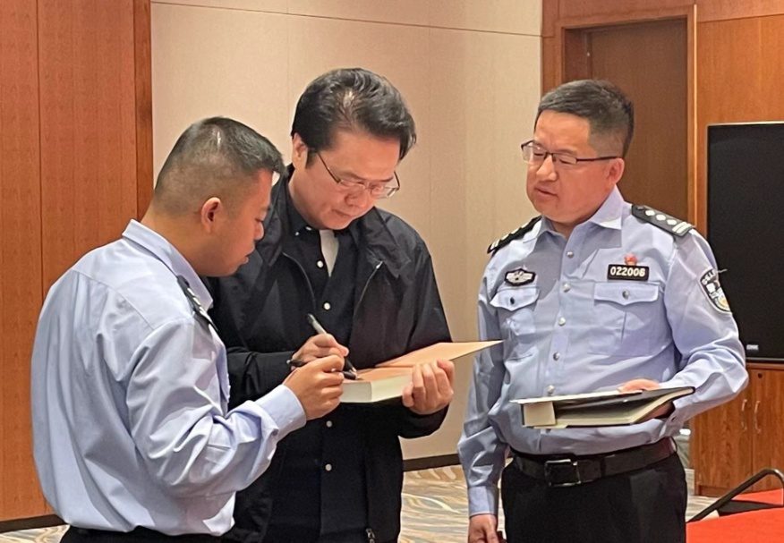 活动期间，陈彦（图中）在给警营作家签名。