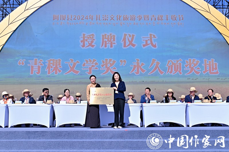 陈亚军主编代表《民族文学》向阿坝县授牌,红梅部长接牌。